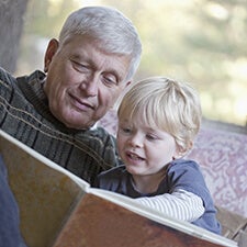 Grandfather reading a book to his grandchild